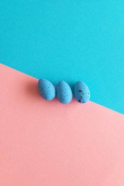 Asgari Paskalya konsepti. Mavi ve pembe arka planda mavi yumurtalar. Üst Manzara. Düz konum, kopyalama alanı. Dikey fotoğraf.