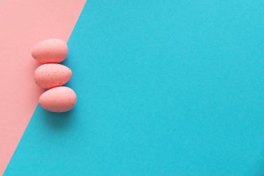 Asgari Paskalya konsepti. Mavi ve pembe arka planda pembe yumurtalar. Üst Manzara. Düz yat, boşluğu kopyala