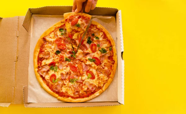 Açık sarı arka planda izole edilmiş lezzetli pepperonili pizza vardı. Dilimlenmiş pizza salamı. Dilimlenmiş pizza pepperonisinin üstünde. Fast food, abur cubur konsepti. Kopyalama alanı olan pankart.