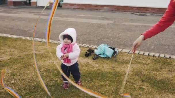 De moeder speelt een regenboog lint met een klein meisje — Stockvideo