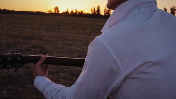 Seul homme jouant de la guitare à l'extérieur au coucher du soleil — Video