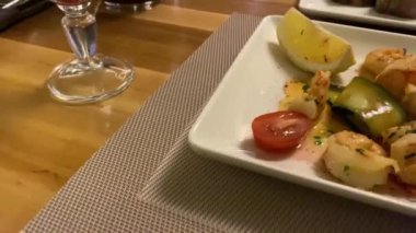 Restorandaki güzel yemek masada, garson taze deniz ürünleri ve çeşitli sebzelerle bir tabak servis etti. İki kişilik lezzetli bir yemek..