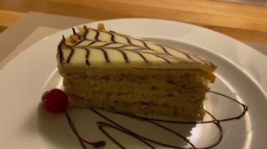 Restorandaki güzel yemekler masada, garson güzel bir tatlıyla birlikte bir tabak servis ediyor. Bu lezzetli bir fındıklı pasta. Beyaz Belçika çikolatasıyla kaplı..