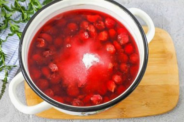 Kirazları tencereye, kazana, tencereye, suya koy ve granüle şeker ekle. Konteynırı ocağa koy ve kaynat. 10-12 dakika kadar kaynayın..