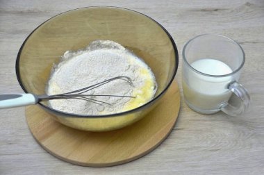 Sütün yarısını dök, un ekle ve karıştır..