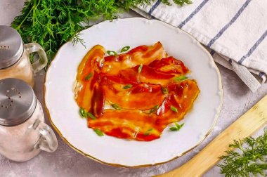 Karamelli pastırmayı bir tabağa koy ve üzerine baharatlı otlar serp..