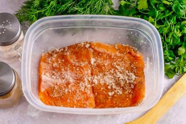 Pembe somon dilimlerini baharat karışımına yerleştir ve her tarafına doğru çevir, hafif basınç kullanarak. Konteynırı ya da kaseyi yapışkan filmle kaplayın, ama tamamen değil! Hava sirkülasyonu için açık alan bırakın, ve kabı 2 yıl soğukta bırakın. 