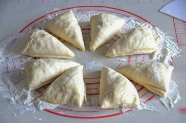 Masanın iş yüzeyini un ile hafifçe tozlayın, hamuru serin, 8 eşit parçaya bölün.