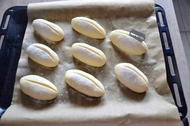 Yarım saat sonra fırını önceden 250 dereceye ısıt. Kahve çekirdeği gibi çörekleri kesmek için jilet ya da keskin bir bıçak kullan. Fırını 10 dakika 250 derecede tut, sonra sıcaklığı 180 dereceye düşür ve 20-25 dakika pişir..