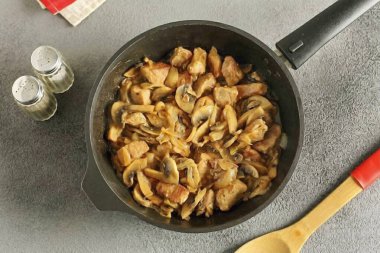 Sonra dilimlenmiş mantarları ekle ve sıvı neredeyse tamamen buharlaşana kadar pişir.