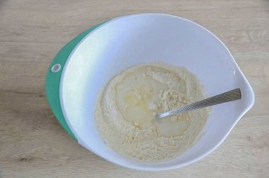 Hamuru masanın çalışma yüzeyine koy, yumuşatılmış tereyağı ekle. Hamuru ellerinle yoğur..