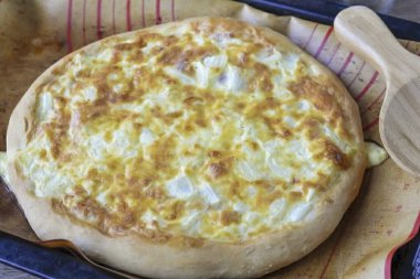 Pizzayı fırında pişir 220-230 derecede 15-20 dakika pişir, kahverengileşene kadar.