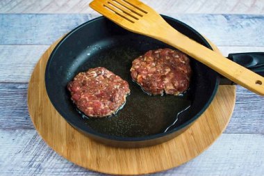 Tuz ve biber tadı için az bir yağ yüzdesiyle kıyma, 1,5 cm kalınlığındaki çöreğin çapından biraz daha büyük çaplı yuvarlak pirzolalar oluşturur. Pirzolaları 4-5 dakika boyunca kızarana kadar ısıtılmış yağda kızart..