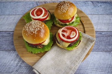 Sonra bir dilim domates, soğan halkaları. Ekmeğin ikinci yarısını mayonezle fırçala, burgeri kapat. Hemen servis yapın.!