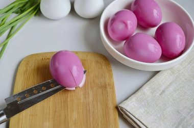 Renkli yumurtaları çıkar ve kağıt havluyla nazikçe sil. Her yumurtanın yarısına kadar haç şeklinde kes. Dikkat et de gelecekteki timsah yapraklarına zarar gelmesin..