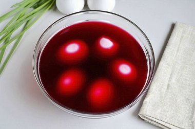 Kaynamış yumurtaları derin bir tabağa koy, pancar suyuyla kapla, biraz soğuk kaynamış su ekle ki yumurtalar tamamen kaplansın. 5 dakika açık bırak..