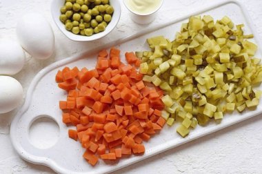 Patatese benzer haşlanmış havuç. Turşuları küçük küplere ayır. Eğer salatalık keserken çok fazla meyve suyu çıkarsa, onu kurutun..