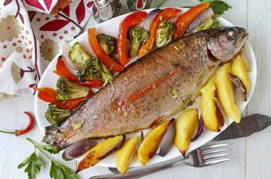 Sebzelerle fırında pişirilmiş lezzetli ve sulu alabalık gerçek bir 