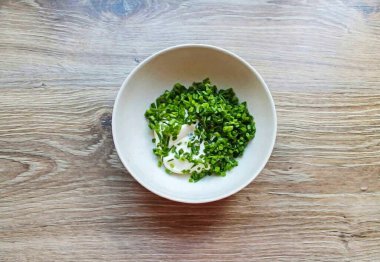 Yeşil soğanları durula, güzelce kurut ve doğra. Mayonez ve soğanı bir kasede birleştir..