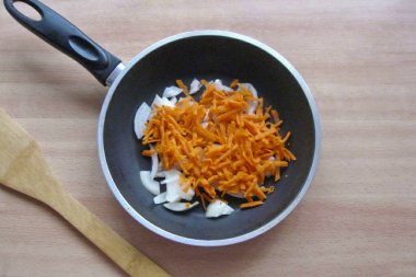 Havuçları soy, yıka ve rendele. Soğana havuç ekle..