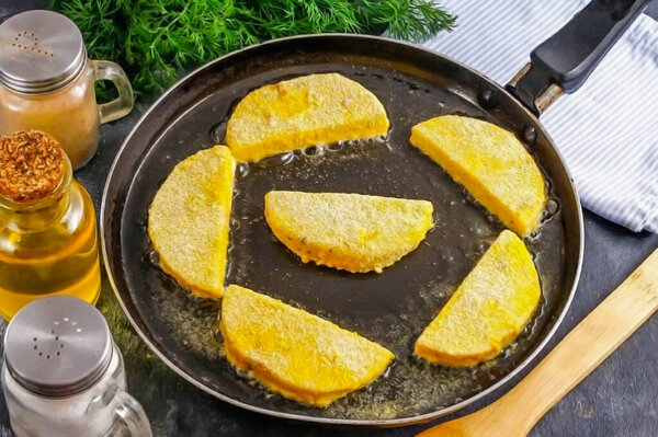 Сделай то же самое для остальной тарелки с сыром. Масло должно быть горячим, чтобы тесто немедленно зажарилось, запечатывая сыр. Жарить с одной стороны около 1-2 минут.