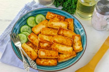 Kızarmış peyniri bir tabağa koy, dilimlenmiş sebze, yulaf lapası, makarna vs. ile sıcak servis et. Kahvaltı için yemek hazırlarken bir fincan aromatik çayı unutmayın.