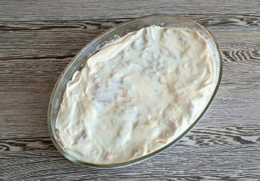 Et katmanını filo örtüsüyle ört. Süt soslu yağ, rendelenmiş peynir. 25 dakika boyunca 180 dereceye ısıtılmış bir fırın koyun. Ta ki altın sarısına.