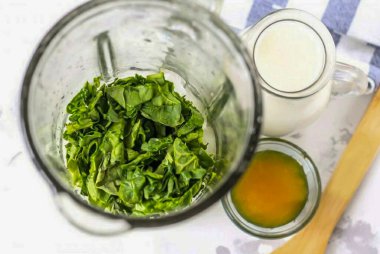 Ispanak yapraklarını iyice yıka, saplarını kes ve yapraklarını kurdele şeklinde kes. Bir blender kasesine koy.