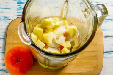 Elmaları suda yıka, çeyreklikleri kes ve çekirdekleri tohumlarla kes. Tekrar durula ve orta küp kes. Dilerseniz, elmaların kabuğunu kesebilirsiniz - meyve daha uzun süre saklanabilsin diye parafinle tedavi edilir. Granüle şeker ekle