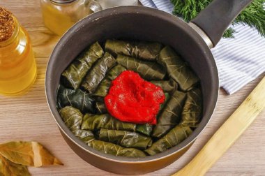Çubuksuz dipli bir kazana ya da kepçeye koy. Domates ezmesi ve bir bardak sıcak su ekle..