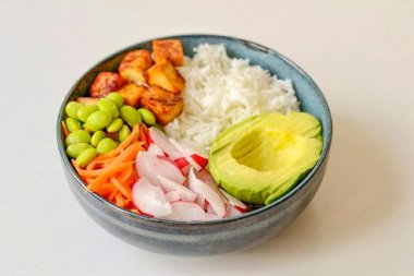 Pirinci derin bir kaseye koy, üstüne sebze ve soya peyniri koy..