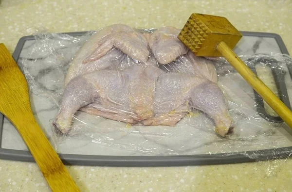Cover the chicken with plastic wrap and beat it off.
