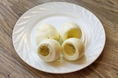 12 dakika kaynattıktan sonra yumurtaları kaynatın. Yumurtaların üzerine soğuk su dök, soğuk ve soyulmuş. Yumurtanın alt kısmını kes, geniş tarafından, ve sarısını dikkatlice çıkar, beyaza zarar vermeden..