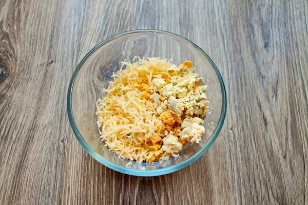 把奶酪放在细碎的烤架上 放在碗里 切碎蛋黄 加入一碗奶酪 — 图库照片