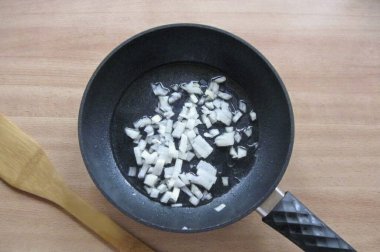 Soğanları soy, yıka ve doğra. Bir tavaya yerleştir.