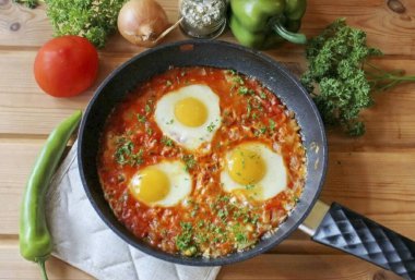 Pişmiş Shakuka 'ya şifalı otlar serp ve sıcak servis yap..