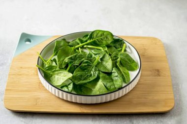 Ispanağı yıka, kurula, kesme tahtasında bir tabağa koy..