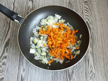 Hamur dinlenirken sebzeleri kızart. 4 tbsp sonra. Sebze yağı, rastgele doğranmış soğan ve havuç..