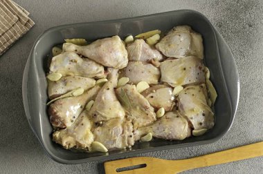 Pour the melted chicken fat over the meat. If there is no fat, use any unscented vegetable oil. Add chopped garlic, hand-crushed bay leaves, and peppercorns. Place the dish in an oven preheated to 120 degrees for 4 hours.