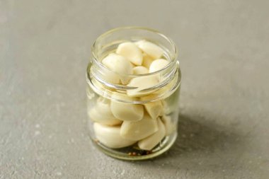 Put all the spices on the bottom of the jar, then the garlic cloves.