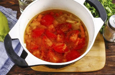 Domatesleri yıka, bir tane bırak, ve onları çeyrekliklere ayır, yeşil çekirdekleri kes. Kazana 2-3 dakika daha kazan ve kaynat. Sonra sıcak suyu dök, kalan tuzu ekle..