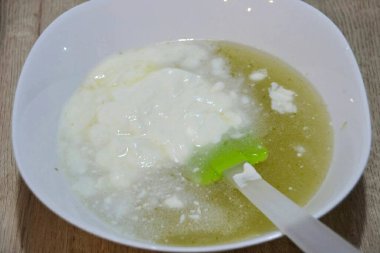 Soğutulmuş limon şekeri şurubuna yoğurt ekle, karıştır ve dondurucuya koy. Buzdolabındaki kütleyi karıştırmak için birkaç kez kaldır. Kütle katı buza dönüşmemeli..