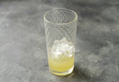 Bardağın altına buz koy. Bir bardağın üçte birini limon ve limon suyuyla doldur..