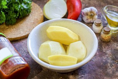 Afgan patatesleri pişirmek için gerekli tüm malzemeleri hazırlayın.