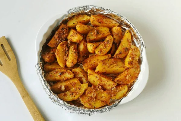 Stir well, rubbing the spices into the potatoes, then transfer them to a greased baking dish and drizzle with oil. Bake in the oven at 200 degrees until browning, stirring occasionally.