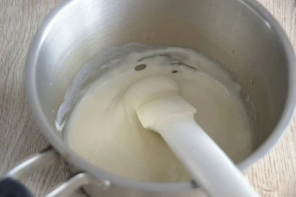 弱火で寒天で牛乳を入れ パッケージ上の方向に応じて熱 厚くなるまで1 2分煮る 質量を冷ます — ストック写真