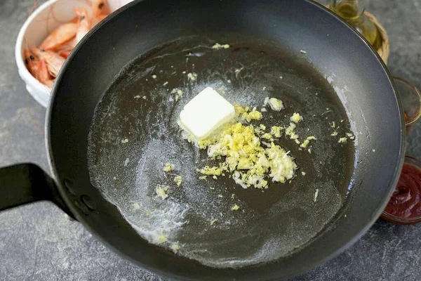 Heat vegetable oil in a frying pan, add a piece of butter, finely grated ginger root and garlic. Grill over medium heat for about a minute.