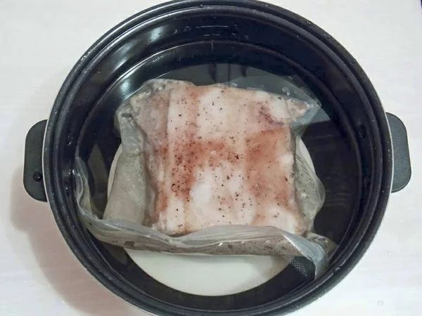 在平底锅底部放一个倒置的盘子 把一袋肉放在盘子里 这样胶卷就不会与墙壁接触 如果你用袋子 一定要确保里面没有水 — 图库照片