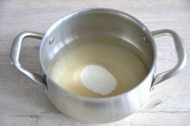 Geniş bir tencereye şeker dökün. Kalın bir tabağı olsun. Suyla kaplayın, şurubu kaynatın..