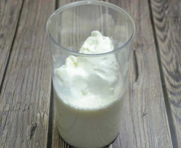 Pour milk and cream into a glass to ice cream, add vanilla sugar.